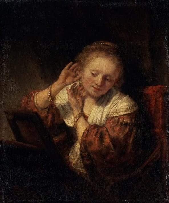 Giovane donna che prova degli orecchini – Rembrandt van Rijn Rembrandt van Rijn 70x85